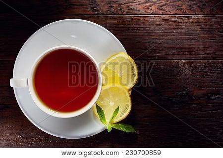 Looking Down On A Cup Of Tea Hot Beverage With Cinnamom, Mint Leaves And Fruits Of Star Anise.