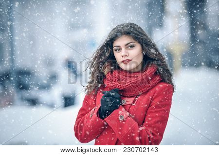 Winter. Girl Brunette Capless Smiles On The Background Of Snow. Close-up. Hair Develops. Wind And Sn
