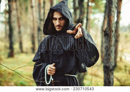 The Black Monk Pointing His Finger In The Woods