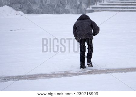 The Child Is Standing On The Ice In The Yard. Poor Boy Without Skates