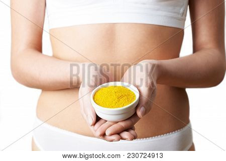 Close Up Of Woman In Underwear Holding Dish Of Tumeric
