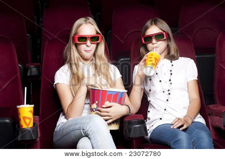 Zwei schöne Mädchen, die einen Film im Kino