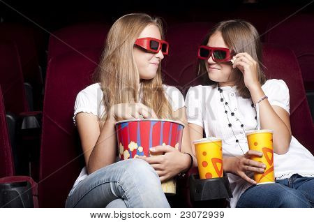 Zwei schöne Mädchen, die einen Film im Kino