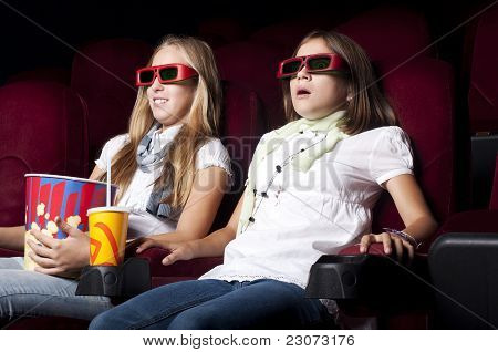 Zwei schöne Mädchen, die einen Film im Kino