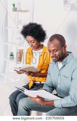 African American Couple Reading Books At Home