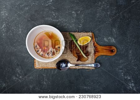 Mushroom Soup With Bread In Ceramic Bowl Served On The Rustic Cutting Board With A Spoon And Linen N