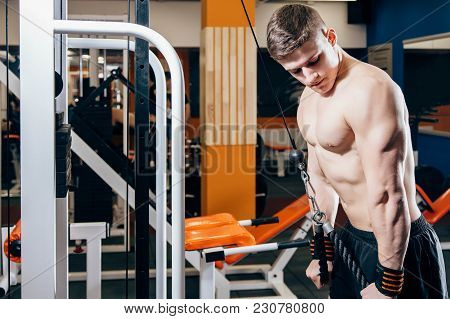 Close-up Of A Young Handsome Man Doing Cable Fly Exercise In Gym