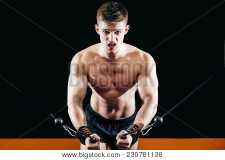 A Young Man Does Hand-cutting On The Simulator In The Gym. Exercise For The Muscles Of The Chest. Cr