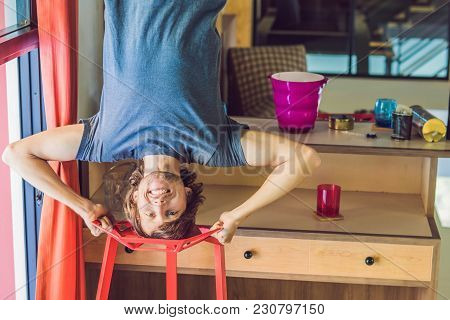 A Man Stands On His Hands Upside Down In The Kitchen.
