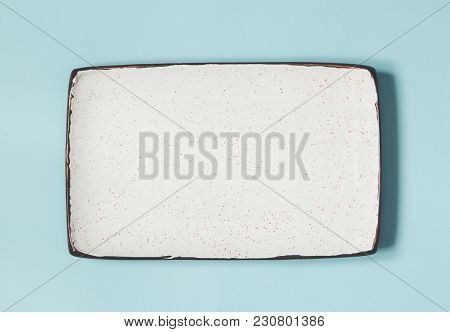 Empty Ceramic Square Plate On Background In Blue Pastel Colors. Top View With Copy Space.
