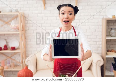 Culinary Blogger Girl In Red Apron Holds Up Blank Tablet To Camera.