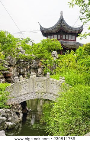 A Arched Stone Bridge With The Classical Chinese Li Yuan Garden In Zhaojialou In Shanghai China On A