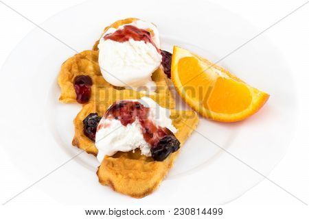 Plate Of Belgian Waffles With Ice Cream, Jam And A Slice Of Orange On White Background.