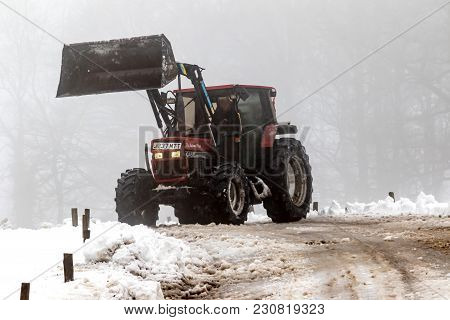 Drewsteignton, United Kingdom, 3rd March 2018:- A Tractor Clears Snow From A Roadway After The Beast
