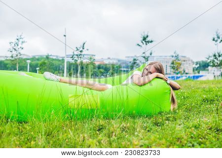Young Woman Resting On An Air Sofa In The Park.. Lamzac