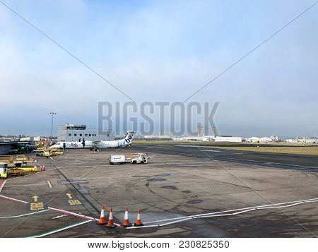 BELFAST, NORTHERN IRELAND - MARCH 12, 2018: A Flybe Bombardier Dash 8 Q400 passenger propeller plane parked at George Best Belfast City Airport in Belfast, County Antrim, Northern Ireland, UK.
