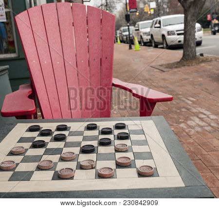 Checkers Game In Public On Sidewalk, Step Up And Take A Seat To Play The Game With A Friend Or Stran