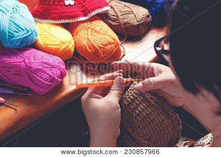 Close Up Hand Of Old Woman Knitting Woolhate On Wooden Table Background