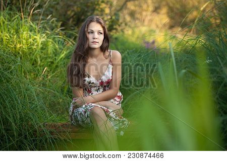 The Young Beautiful Girl, With A Bouquet Of Flowers, Has A Rest And Enjoys Beauty Of The Nature In T