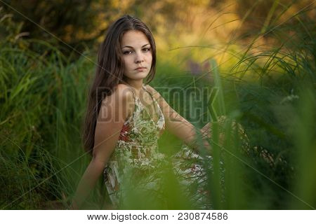 The Young Beautiful Girl, With A Bouquet Of Flowers, Has A Rest And Enjoys Beauty Of The Nature In T