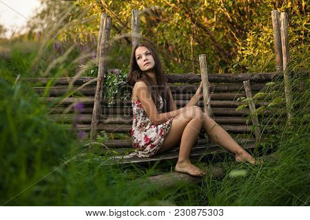 The Young Beautiful Girl, With A Bouquet Of Flowers, Has A Rest And Enjoys Beauty Of The Nature In T