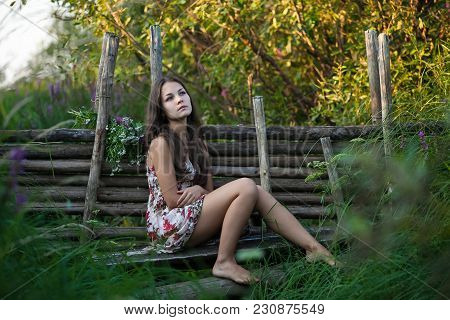 The Young Beautiful Girl, With A Bouquet Of Flowers, Has A Rest And Enjoys Beauty Of The Nature In T