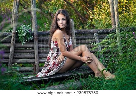The Young Beautiful Girl, With A Bouquet Of Flowers, Has A Rest And Enjoys Beauty Of The Nature In T