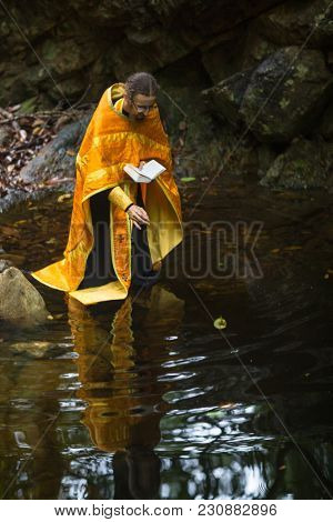 KOH CHANG, THAILAND - MAR 9, 2018: Orthodox priest during sacrament of spiritual birth - Baptism. There are currently 10 Orthodox parishes in Thailand, Orthodoxy is practiced by 0.002% of population.