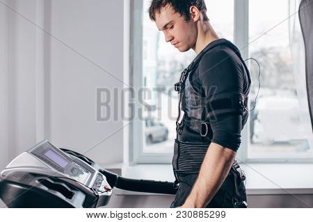 Fit Man In Black Suit For Ems Training Preparing For Running On Treadmill At Gym