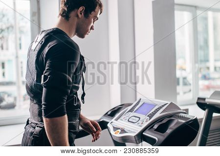 Fit Man In Black Electric Muscle Stimulation Suit For Ems Training Running On Treadmill At Gym