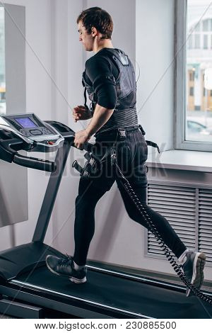 Fit Man In Black Suit For Ems Training Running On Treadmill At Gym