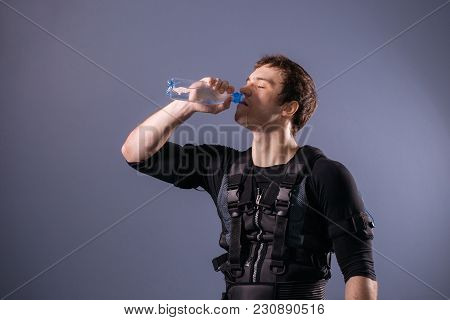 Fit Man Wearing Electro Stimulation Suit Drink Water After Training