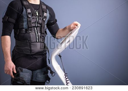 Male Athlete Select Intensity Of Ems Electro Muscular Stimulation Machine