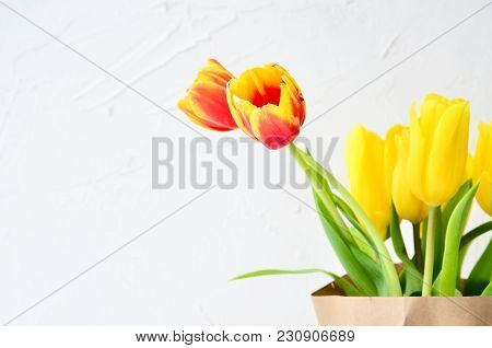 Bouquet Of Yellow And Orange Tulips In A Kraft Paper On A White Background, Concept Of Women's Day O