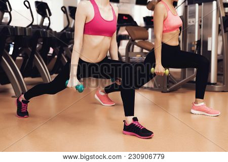 Mother And Daughter In Sportswear Doing Exercises With Dumbbells At The Gym. They Look Happy, Fashio