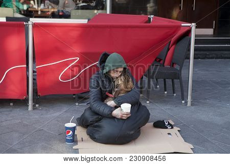 London, England - July 12, 2016 A Beggar Asleep And Holding A Dog In His Arms