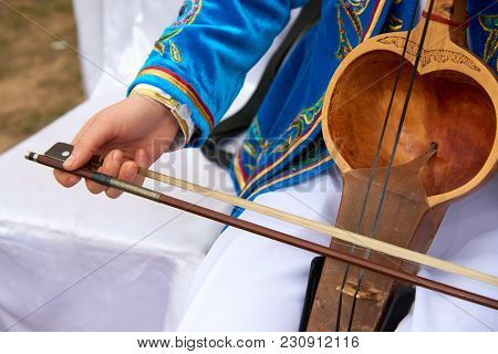 Playing A Musical Instrument Kobyz.
The Kobyz Or Qıl-kobız Is An Ancient Kazakh String Instrument. I