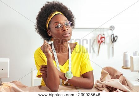 Smiling African Seamstress Looking At Camera With Sewing Machine