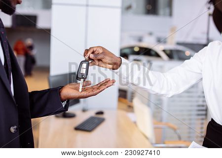Young Car African Female Salesman Giving A Key From The New Car To The Beautiful Young African Coupl