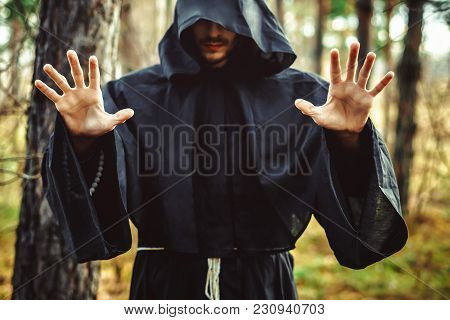 The Black Monk Pointing His Finger In The Woods