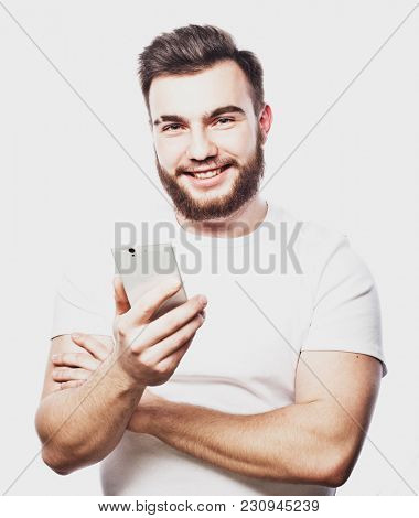 Tehnology and people concept: Bearded man  typing sms on white  background