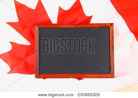 Blackboard With The National Flag Of Canada Drawn On And A Chalk