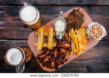 Assorted Beer Snacks With Cheese Sticks, Chicken Wings, Salted Peanuts, French Fries And Garlic Brea