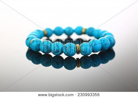 Bracelet Of Bijouterie Jewelry Made Of Turquoise And Gold On A Gray Black Background