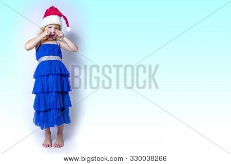 Portrait Of Four Year Old Cute Little Girl In The Santa Claus Hat Crying In Tantrum. Copy Space