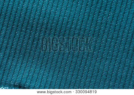Close-up Fragment Of A Beautiful Green Knitted Fabric For Sewing Warm Things. Concept Of High-qualit