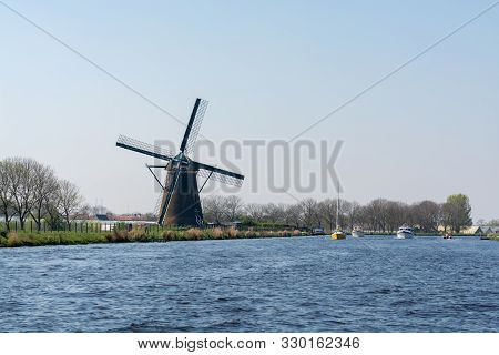 Waterways Of North Holland With Boats And View On Traditional Dutch Mill, Spring Landscape