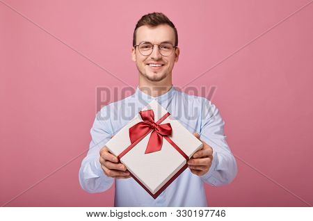 A Pleasantly Surprised Man In A Delicately Blue Shirt With Black Glasses Holds A Gift In A Box With