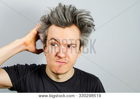 Unshaven Long Haired Guy Offended And Matures On A Gray Background