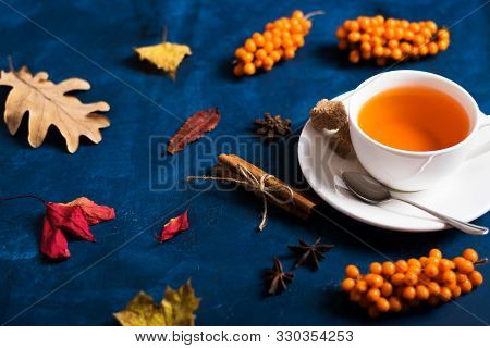 Tea In A White Cup On A Saucer, Dark Background, Sea Buckthorn Berries
